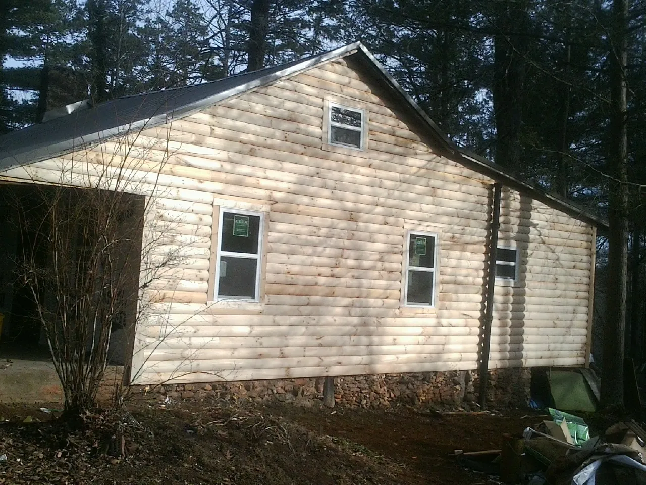 New log siding and dark metal roofing on a gable end in Heyburn