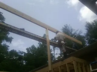 Carpenter setting a ridge beam over a new addition frame — Ice Dam Removal by Roofing Brothers in Heyburn