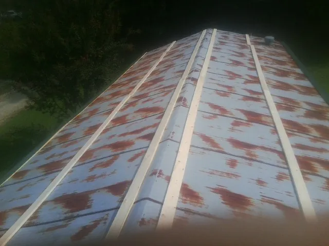Rusted metal roof panels with new wood purlins before replacement — Storm Damage Roof Repair in Heyburn by Roofing Brothers