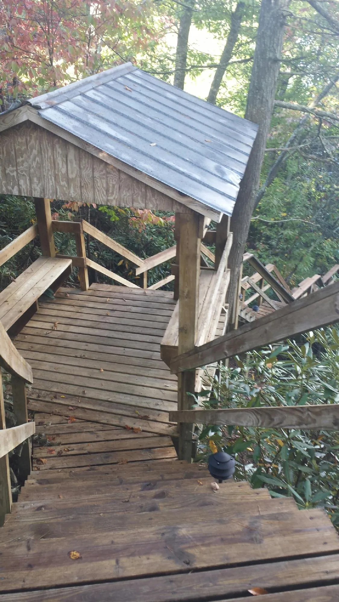Metal roofed shelter over wooden steps on a wooded walkway — Skylight Repair & Installation work by our crew in Heyburn