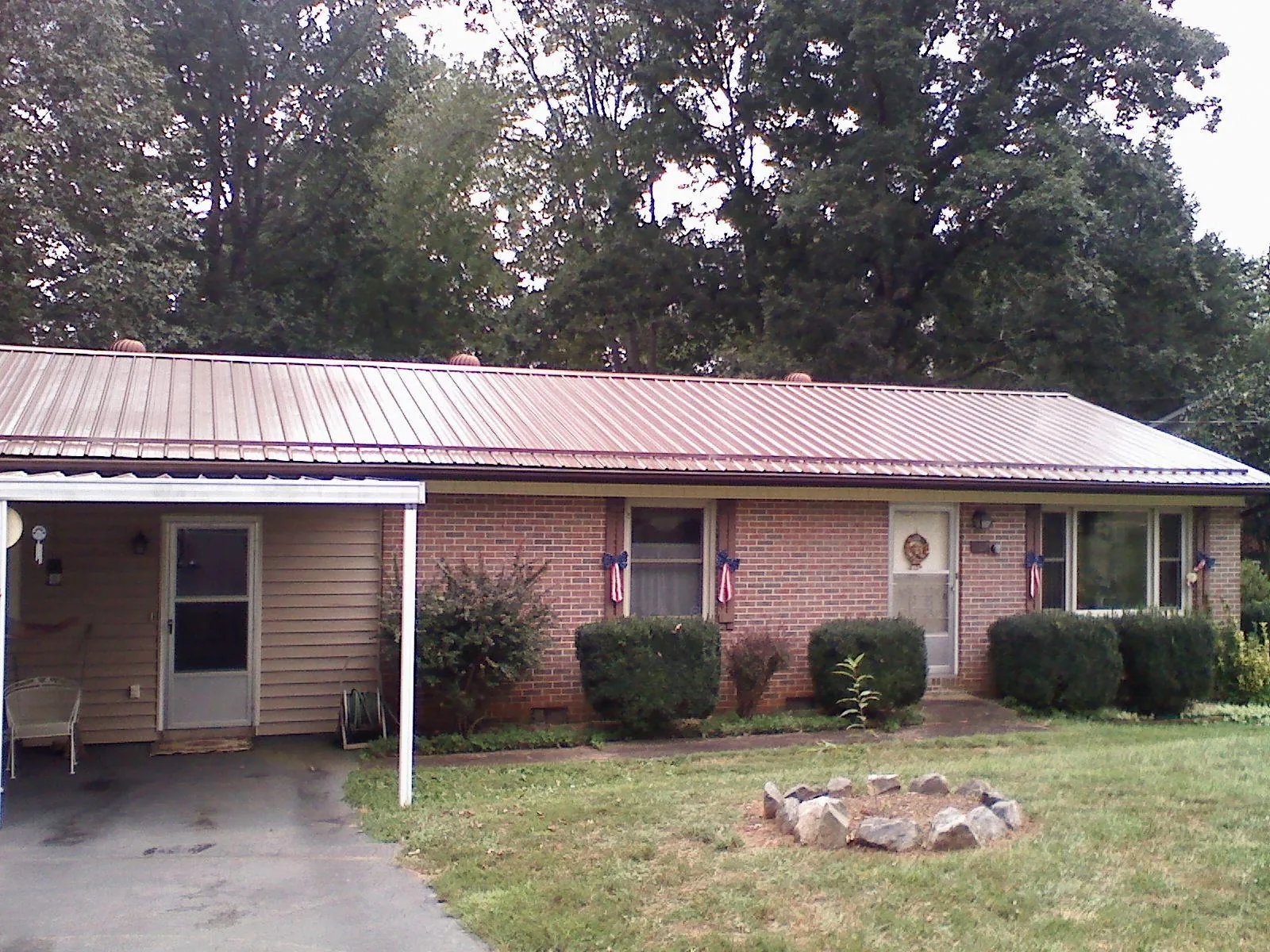 Bronze metal roof and carport on a brick ranch home — Roof Repair work by our crew in Heyburn